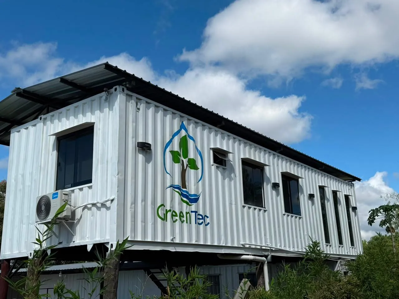 Oficina ejecutiva en contenedor de 40 pies elevada sobre pilotes de madera, vista frontal completa