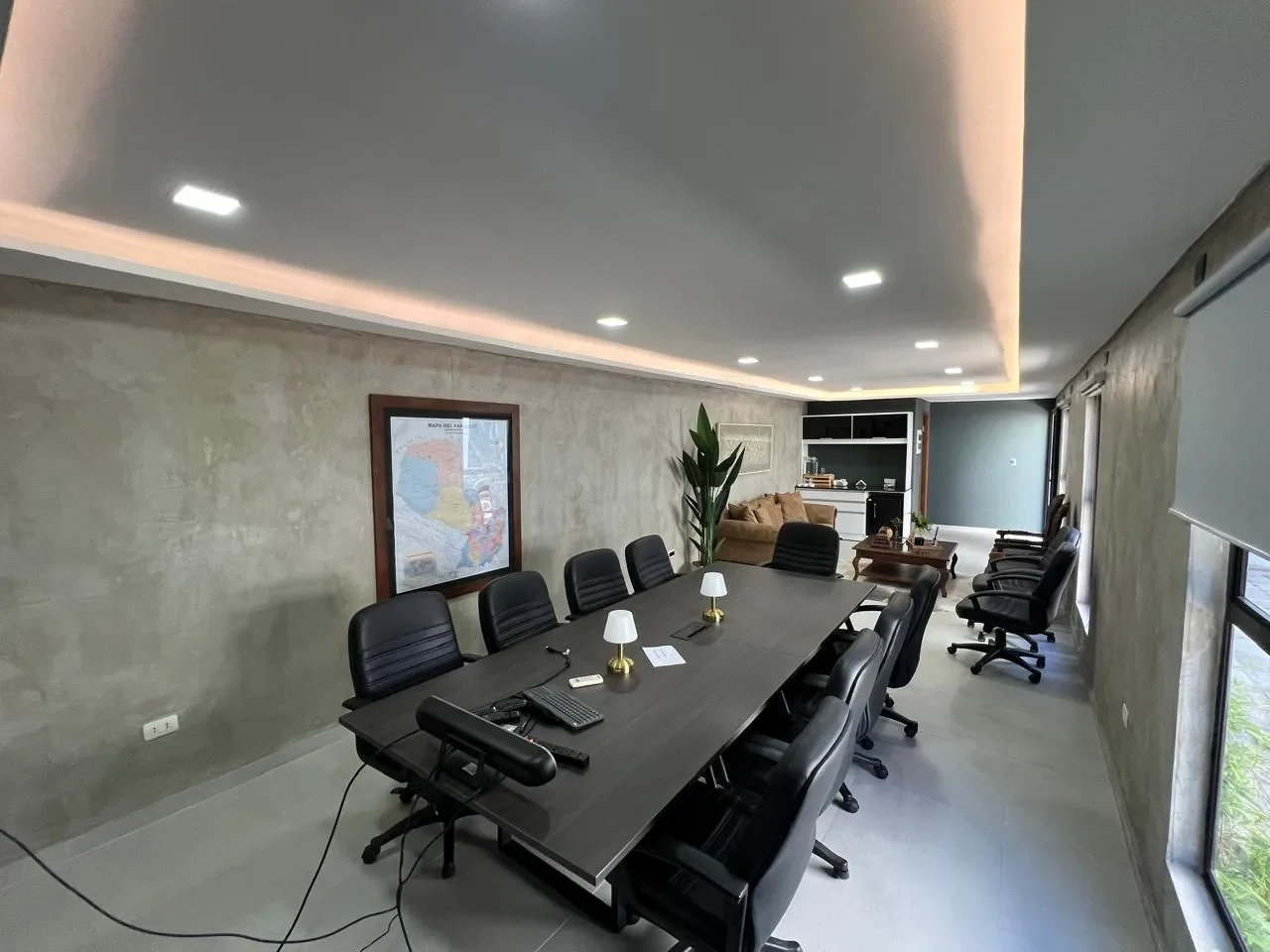 Oficina ejecutiva premium en contenedor con sala de directorio, microcemento, mapa del Paraguay, sofa de terciopelo y kitchenette.